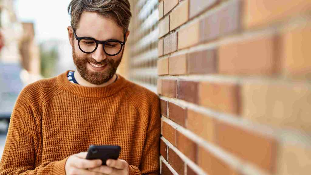 Homem busca informações sobre renda fixa em seu smartphone.