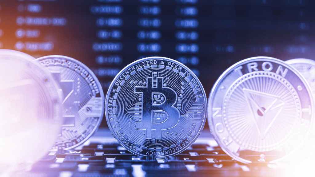 Bitcoin em destaque no teclado, representando a negociação de criptomoedas e, por consequência, o potencial de investimento em ETFs como o HASH11, que replica o índice de criptoativos.