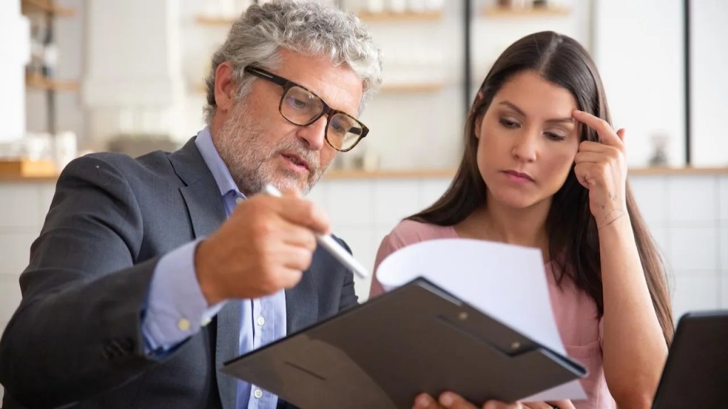 consultor financeiro com uma pasta na mão explicando para a cliente como funciona o precatório.