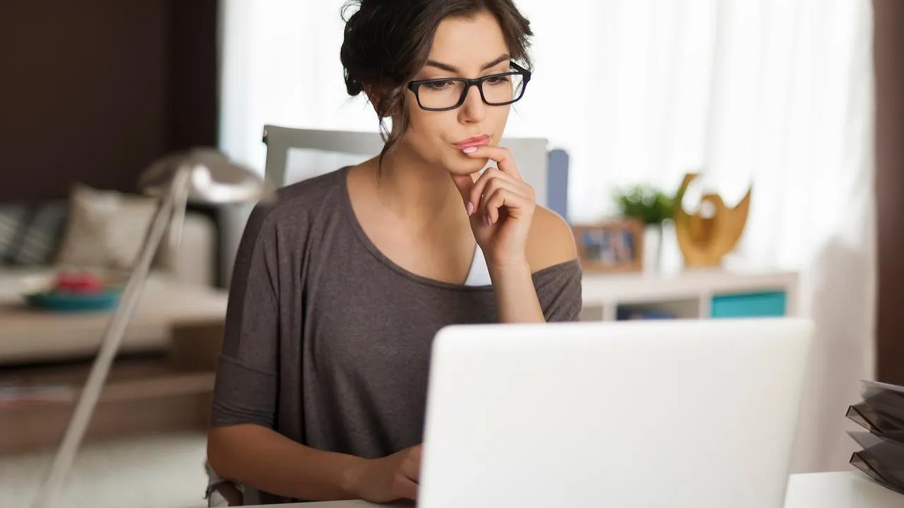 mulher concentrada pesquisando em seu laptop como funciona o mecanismo de ressarcimento de prejuízos